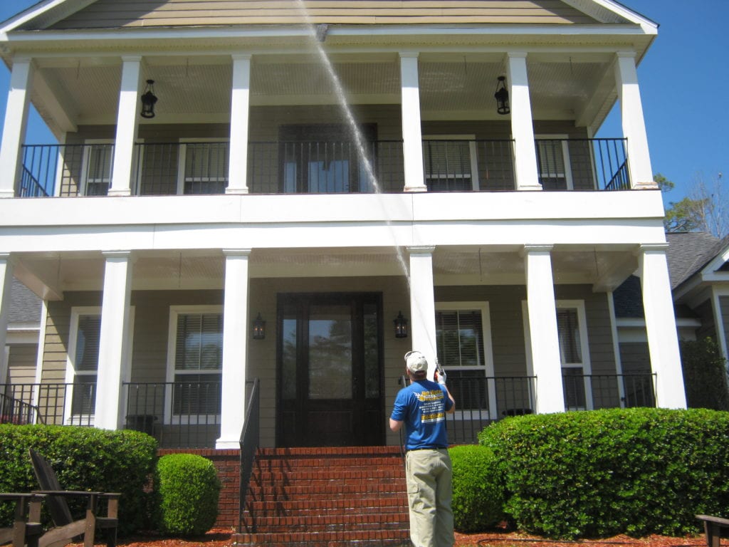 Man washing home exterior