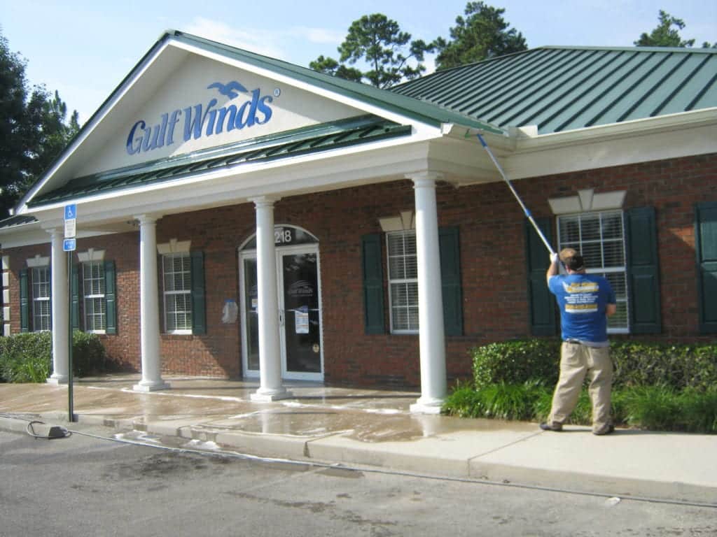 Gutter cleaning company cleaning gutters on a bank in Tallahassee, FL.