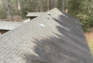 Shingles on roof getting a soft wash cleaning treatment.