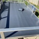 Installing a polyvinyl mat on the wood floor of a new pressure washing trailer