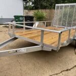 Side view of a new aluminum utility trailer with a wooden deck, ready to be outfitted for a pressure washing rig.