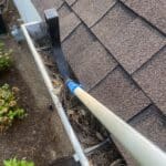 From my view on the ladder, I'm using the Gutter Hawg's scoop to pull heavy gutter debris towards me for easy removal.