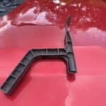A close-up image of The Gutter Hawg, a durable black plastic attachment used for cleaning rain gutters from a ladder.
