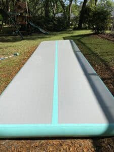 The same inflatable gymnastics mat, now perfectly clean and bright after the removal of all algae and mildew stains, looking brand new.