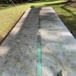 A dirty inflatable gymnastics mat covered in green algae before being cleaned.