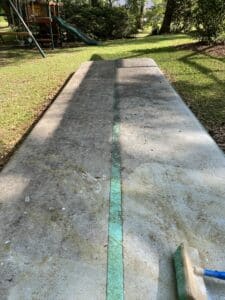 Close-up of a dirty inflatable gymnastics mat showing heavy buildup of slippery green algae and mildew spots prior to cleaning.