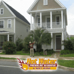 A professional from Hot Water Pressure Washing soft washing the siding of a large, two-story home in the SouthWood community in Tallahassee, FL.