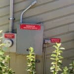 The exposed generator isolation switch panel on a home's exterior before being professionally protected for a house wash in Tallahassee, Florida.