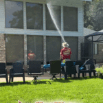A technician performing a professional Soft Wash House Washing service on a large home for a repeat client in the McBride Hills community of Tallahassee, FL.
