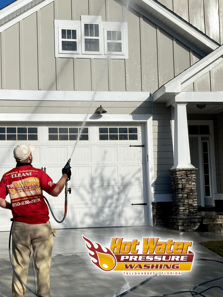Nick Loomis, owner of Hot Water Pressure Washing, performing a professional Soft Wash House Washing service on a residential home in Tallahassee, Florida, featuring the company logo watermark.