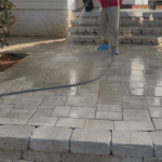 A Hot Water Pressure Washing technician safely soft washing a brick paver patio in the Southwood neighborhood of Tallahassee, Florida.