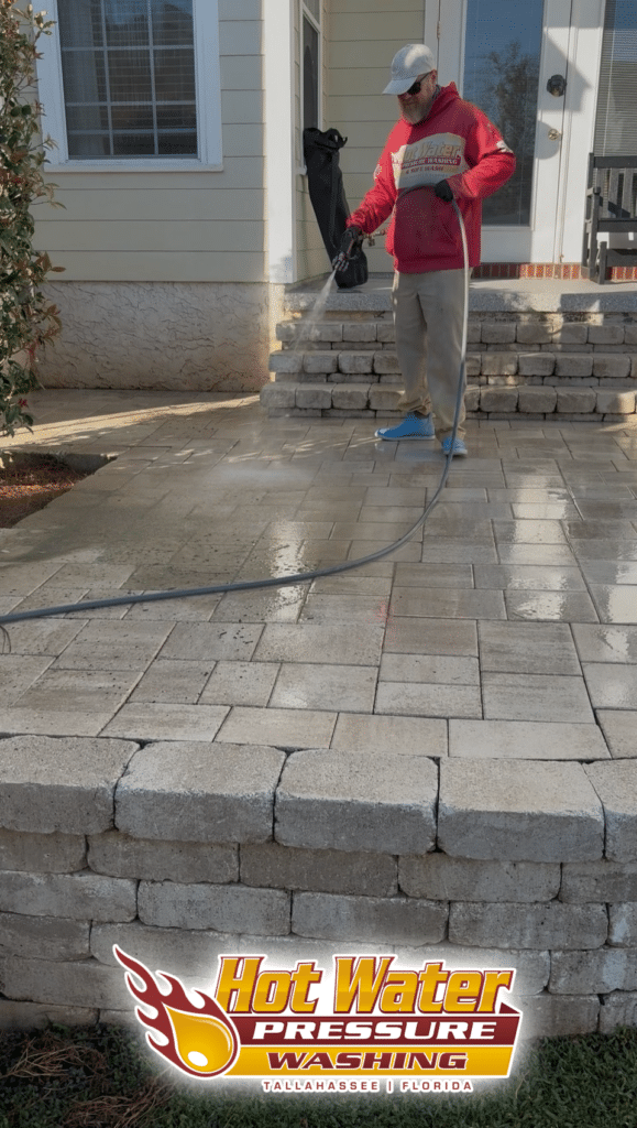 A Hot Water Pressure Washing technician safely soft washing a brick paver patio in the Southwood neighborhood of Tallahassee, Florida.