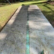 A dirty inflatable gymnastics mat covered in green algae before being cleaned.